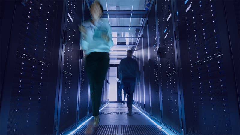 Shot Of Corridor In Large Data Center Full Of Walking And Working People