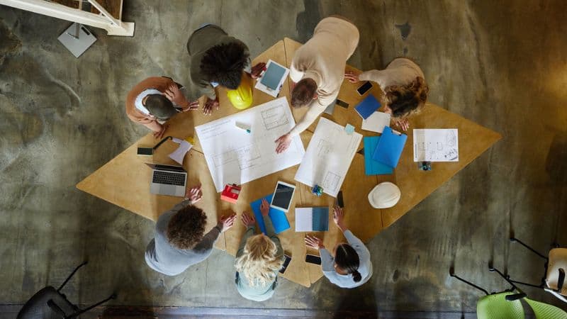 Above View Of Interior Designers Working On Plans In The Office